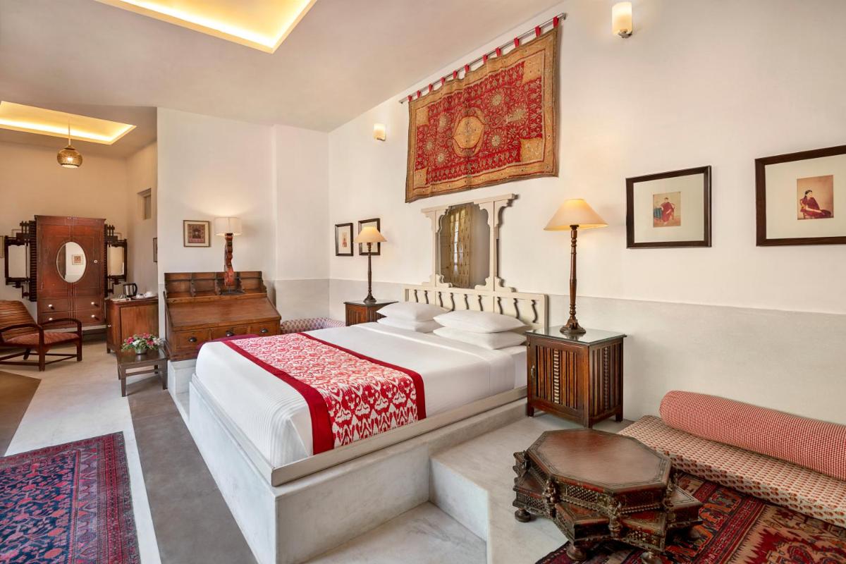 a bedroom with a large bed and a piano at Neemrana Fort-Palace in Neemrana