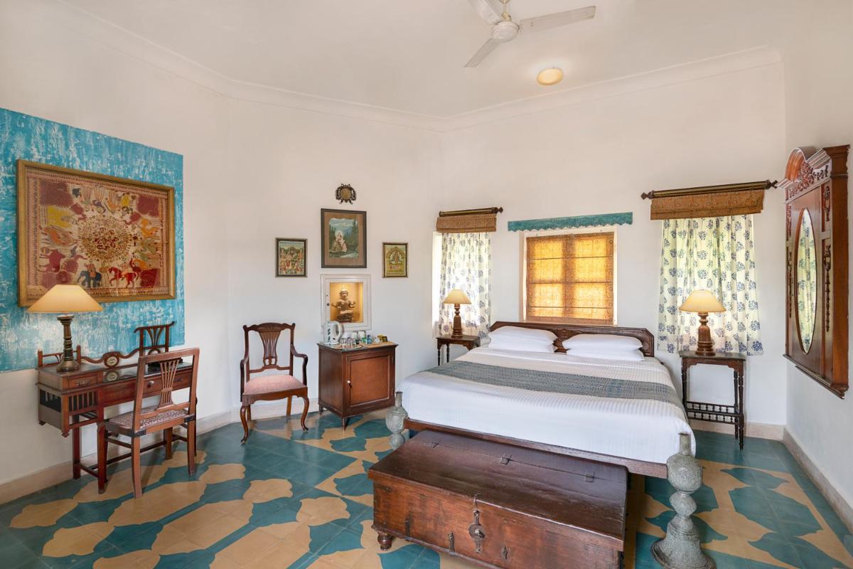 a bedroom with a bed and a table and chairs at Neemrana Fort-Palace in Neemrana