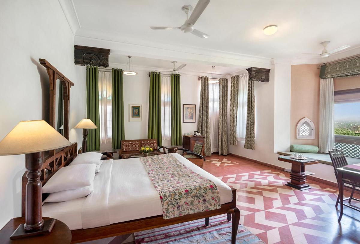 a bedroom with a large bed and a living room at Neemrana Fort-Palace in Neemrana
