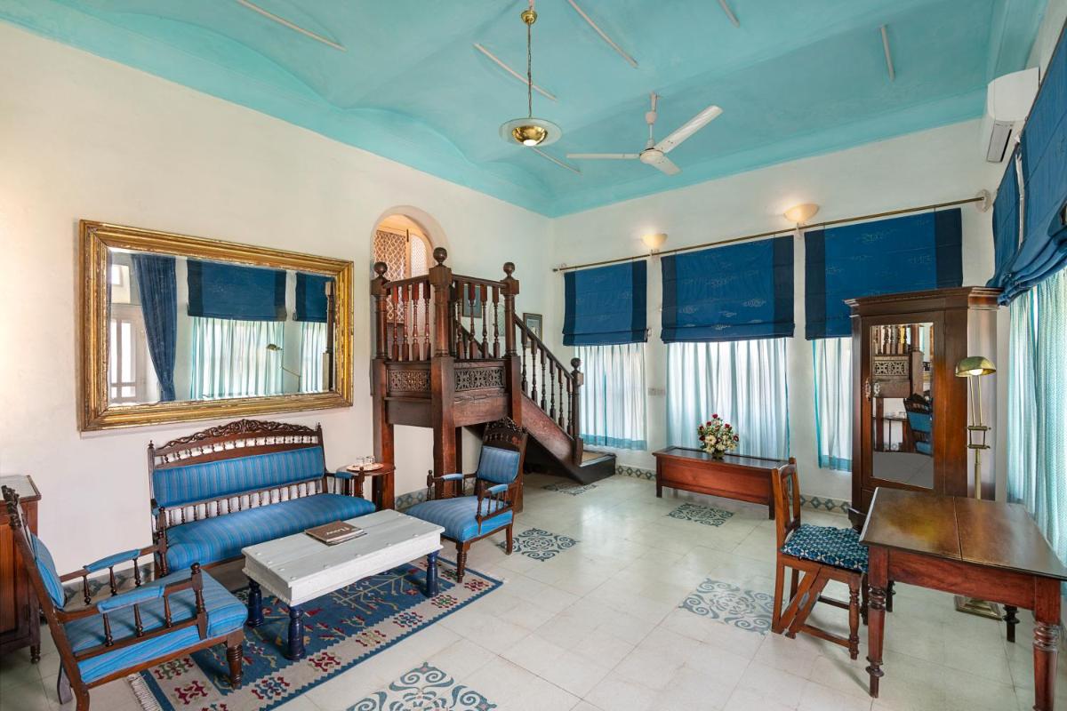 a living room with a couch and chairs and a piano at Neemrana Fort-Palace in Neemrana