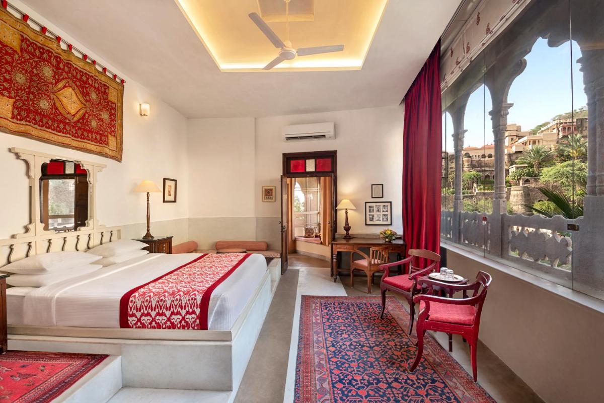 a bedroom with a bed and a large window at Neemrana Fort-Palace in Neemrana