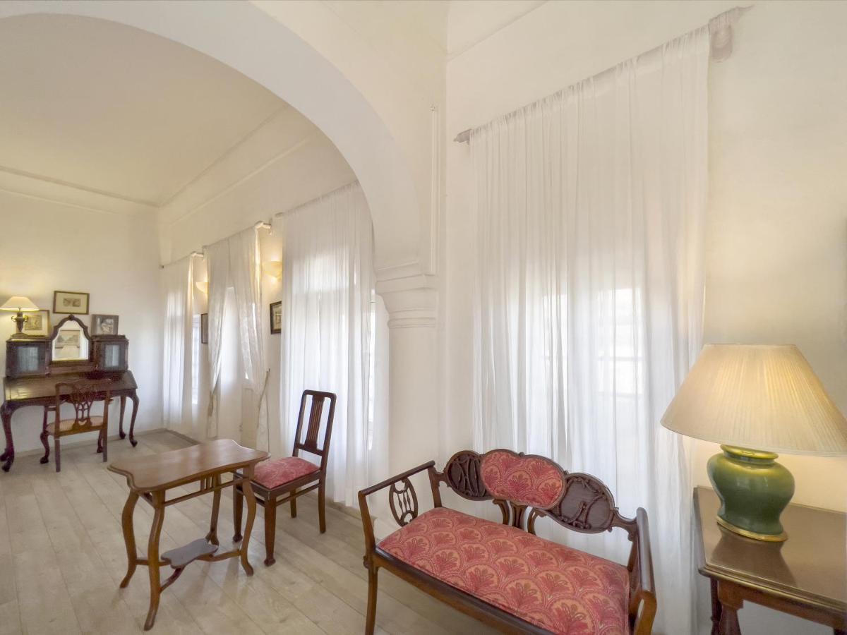 a living room with a table and chairs and a lamp at Neemrana Fort-Palace in Neemrana