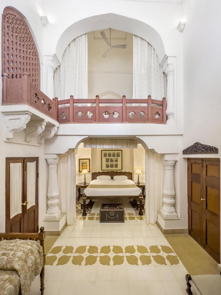 a large room with a bed and a balcony at Neemrana Fort-Palace in Neemrana
