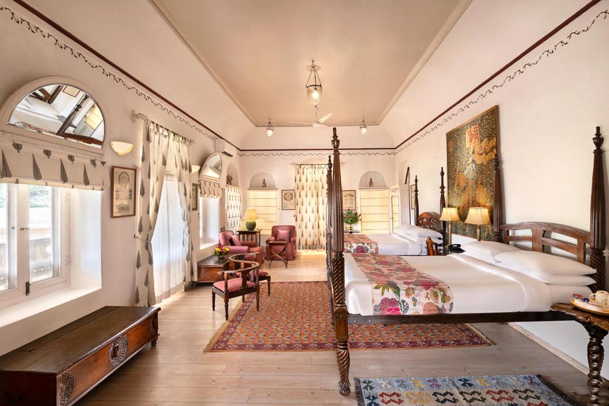 a bedroom with a bed and a desk and a room with at Neemrana Fort-Palace in Neemrana