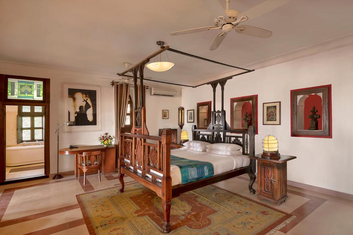 a bedroom with a bed and a ceiling fan at Neemrana Fort-Palace in Neemrana