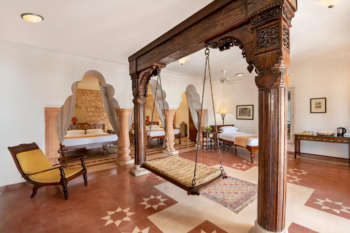 a room with a swing and a bedroom at Neemrana Fort-Palace in Neemrana