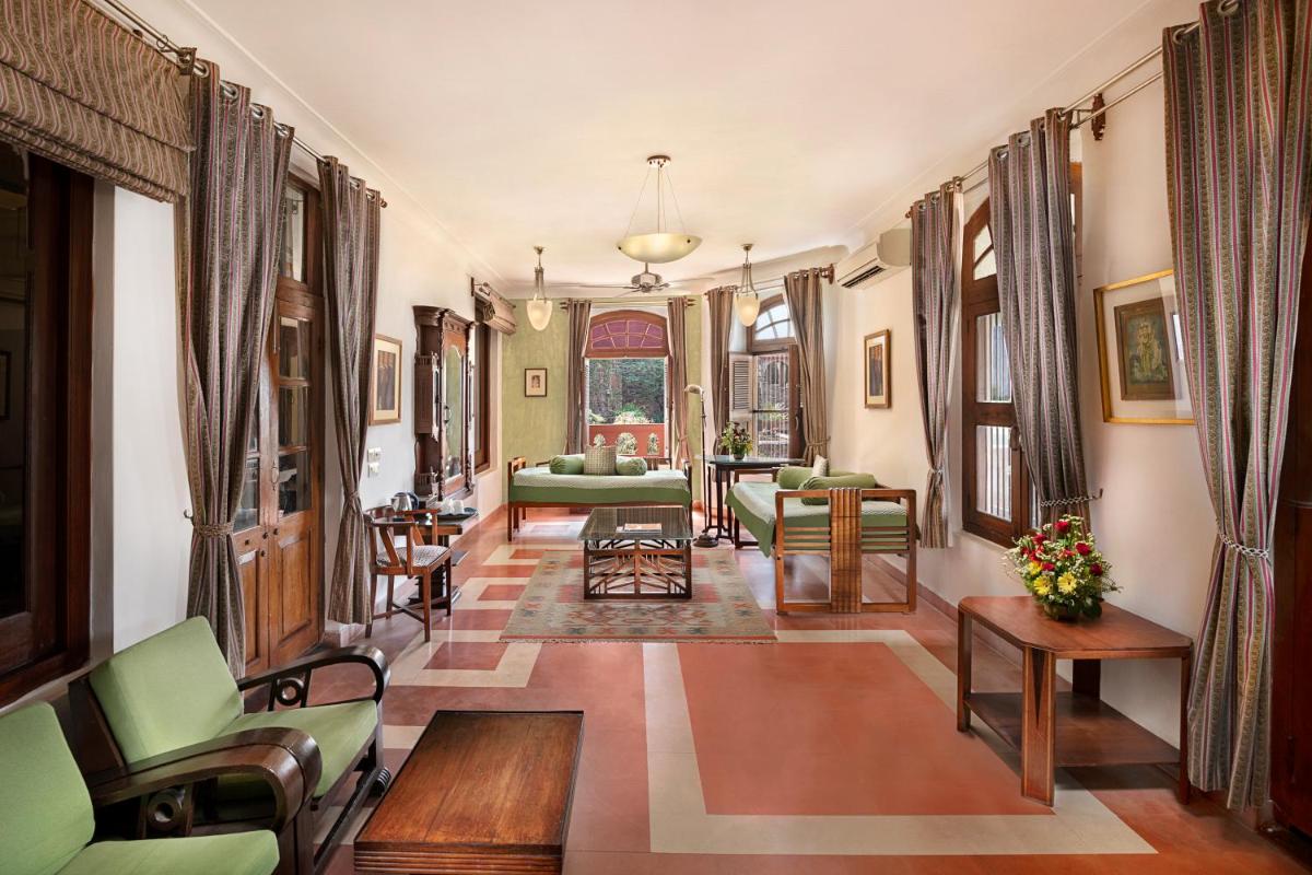 a living room with green chairs and a couch at Neemrana Fort-Palace in Neemrana