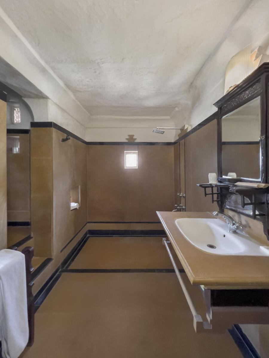 a bathroom with a sink and a mirror at Neemrana Fort-Palace in Neemrana