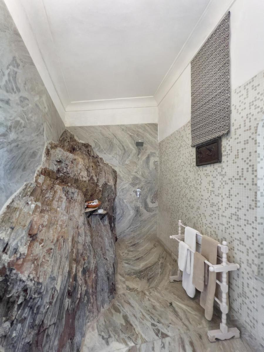 a bathroom with a large rock mural on the wall at Neemrana Fort-Palace in Neemrana