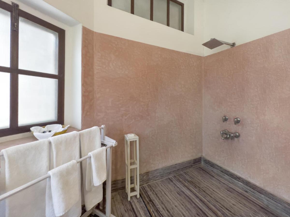 a bathroom with white towels and a window at Neemrana Fort-Palace in Neemrana