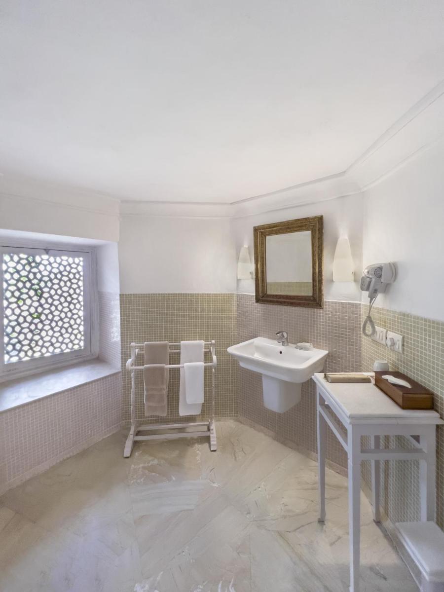 a bathroom with a sink and a mirror at Neemrana Fort-Palace in Neemrana