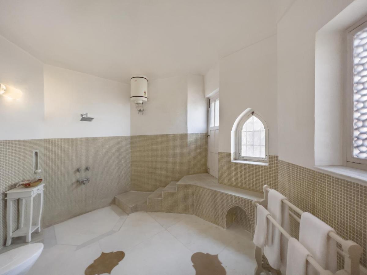 a bathroom with a tub and a toilet and a sink at Neemrana Fort-Palace in Neemrana