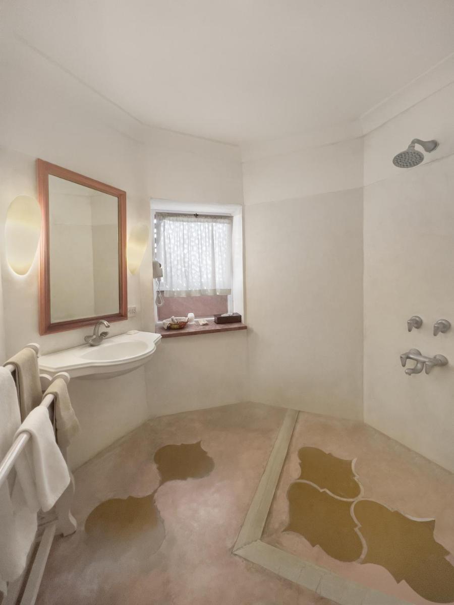 a bathroom with a sink and a mirror at Neemrana Fort-Palace in Neemrana