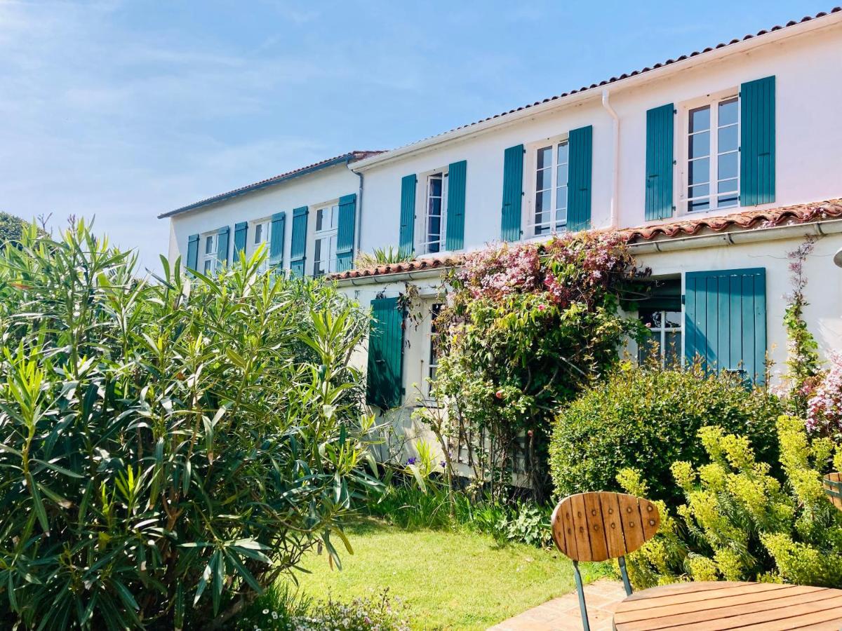 un bâtiment avec volets bleus dans l'établissement Le Chat Botté, à Saint-Clément-des-Baleines