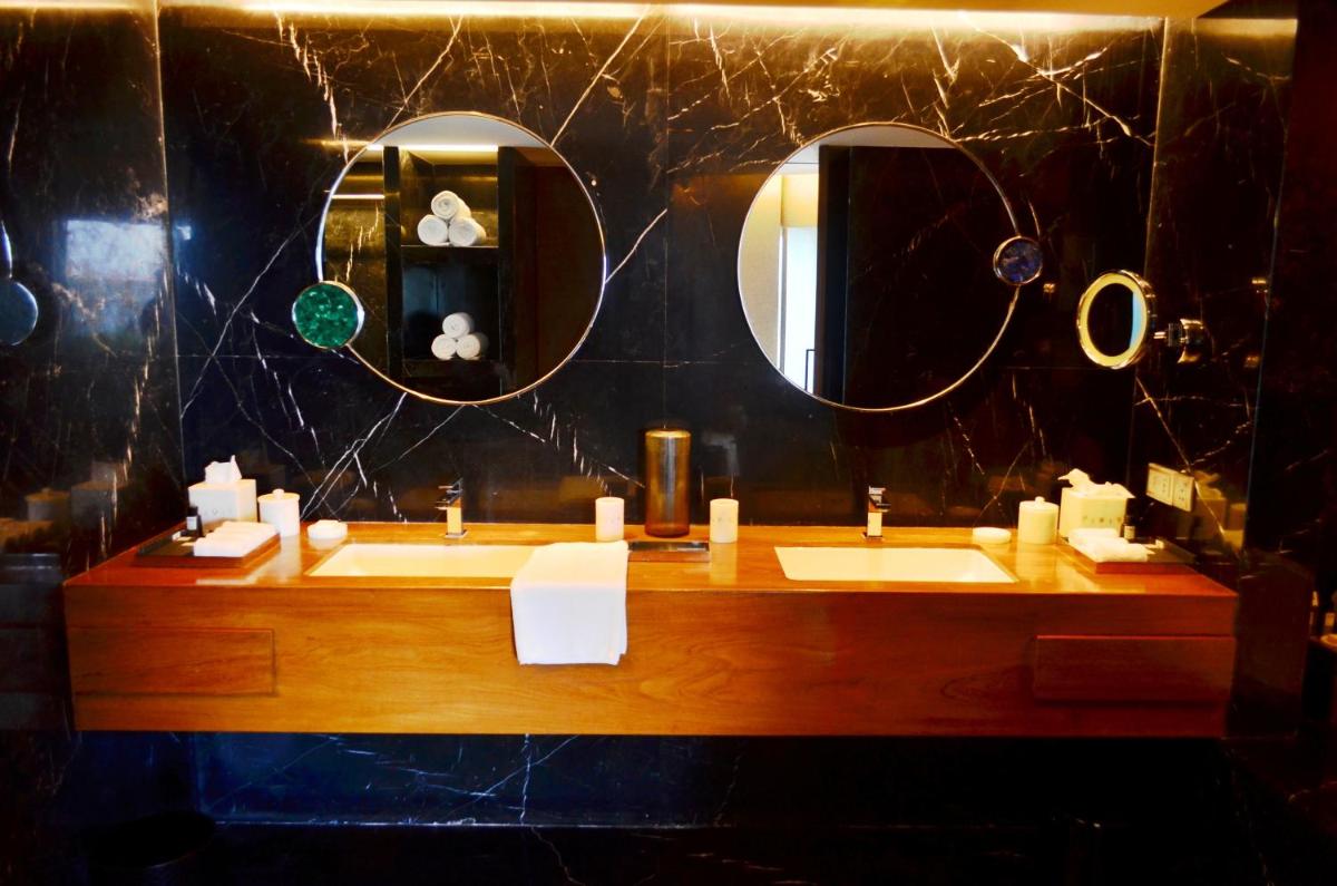 a bathroom with two sinks and two mirrors at The Park Hyderabad, Banjara Hills near Hussain Sagar Lake in Hyderabad a bathroom with two sinks and two mirrors at The Park Hyderabad, Banjara Hills near Hussain Sagar Lake in Hyderabad