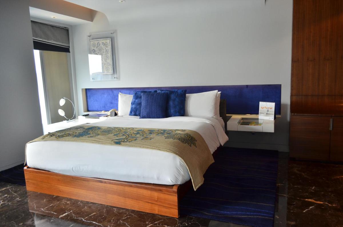 a bedroom with a large bed with a blue headboard at The Park Hyderabad, Banjara Hills near Hussain Sagar Lake in Hyderabad a bedroom with a large bed with a blue headboard at The Park Hyderabad, Banjara Hills near Hussain Sagar Lake in Hyderabad