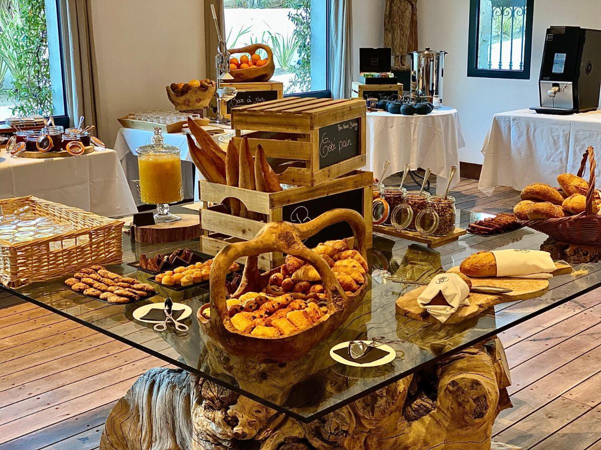 une table avec un étalage de pains et de pâtisseries dans l'établissement Hôtel Le Roi Théodore & Spa, à Porto-Vecchio