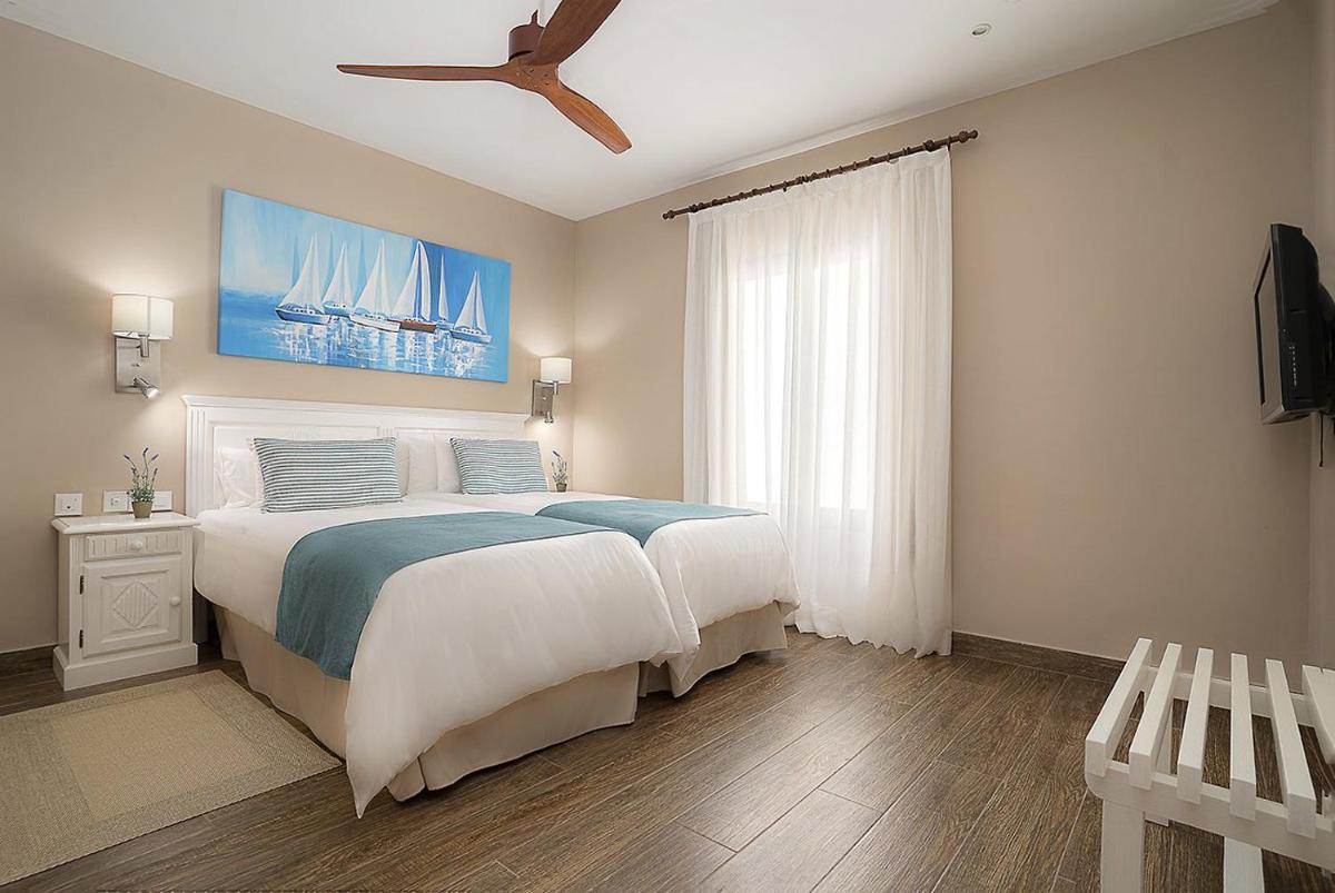 Un dormitorio con una cama grande y un ventilador de techo. en LANZAROTE PRIME SPORTS by Vitalclass Lanzarote Resort, en Costa Teguise 23 fotos más