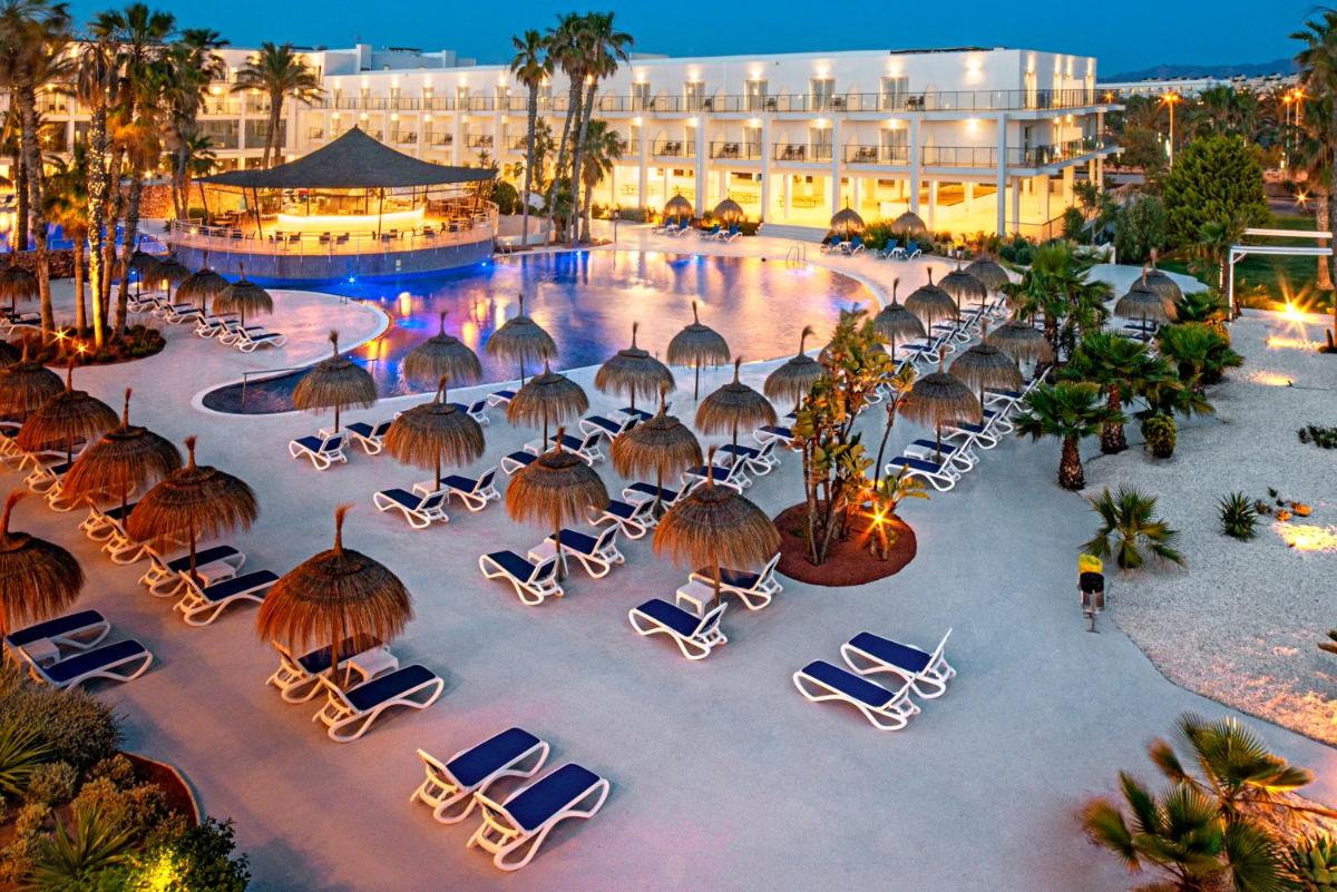 una vista aérea de una piscina del hotel con sillas y sombrillas en Hotel Cabogata Jardín, en Retamar