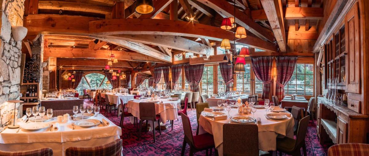 un restaurant avec des tables et des chaises dans une salle dans l'établissement Hôtel LE BLIZZARD, à Val dʼIsère