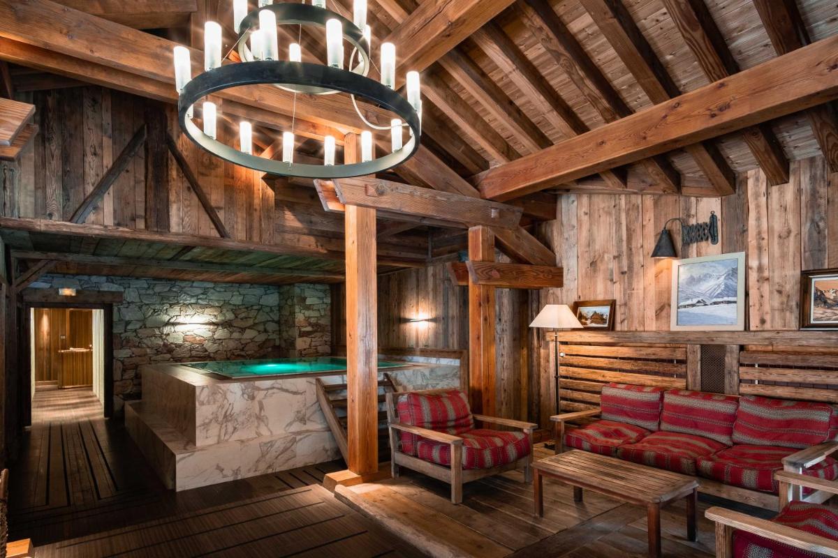 une pièce avec une table, des chaises et un lustre dans l'établissement Hôtel LE BLIZZARD, à Val dʼIsère