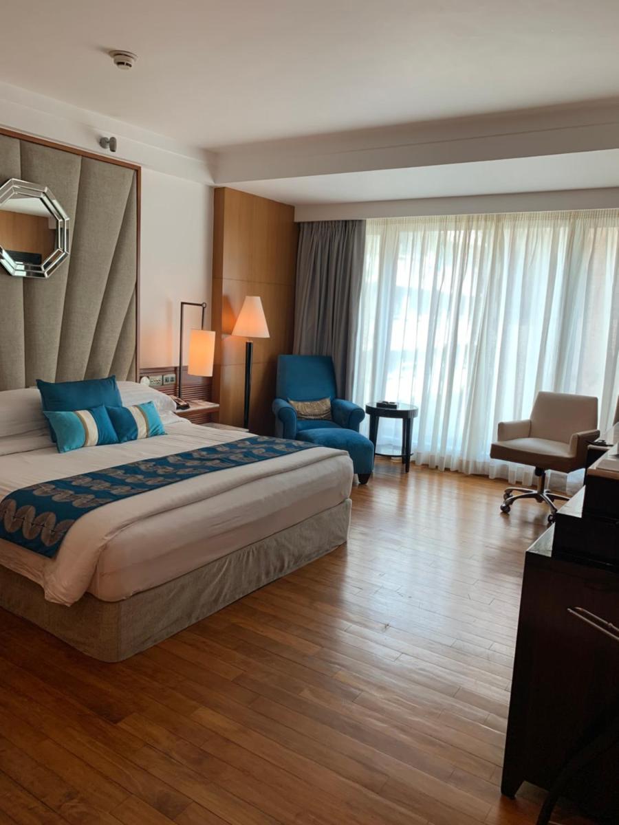 a hotel room with a large bed and a chair at InterContinental Marine Drive Mumbai by IHG in Mumbai