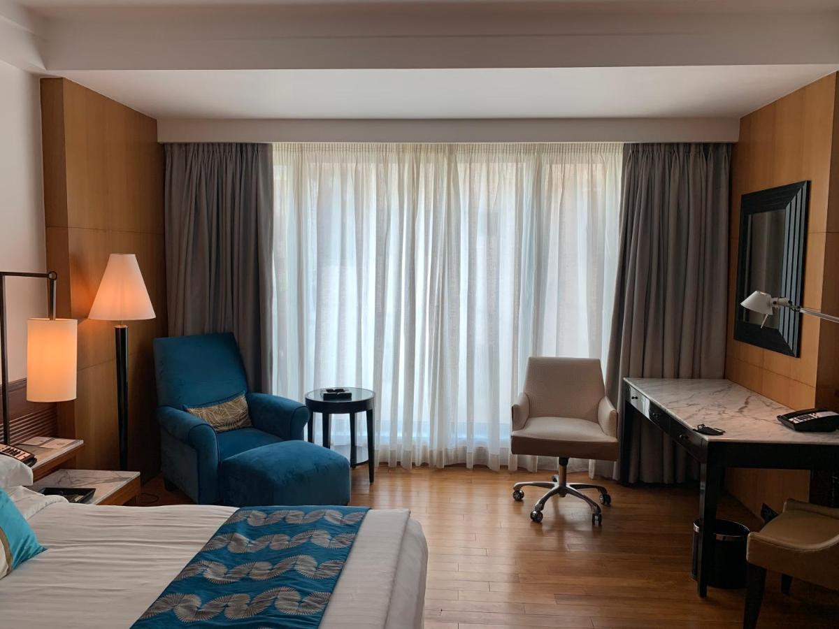 a hotel room with a bed and a desk and a chair at InterContinental Marine Drive Mumbai by IHG in Mumbai