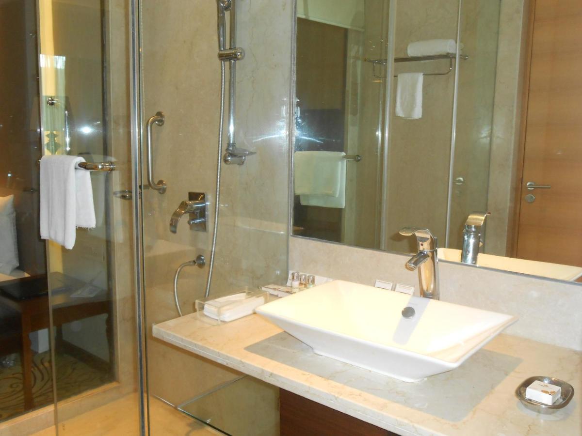 a bathroom with a sink and a shower at Pride Plaza Hotel, Kolkata in Kolkata