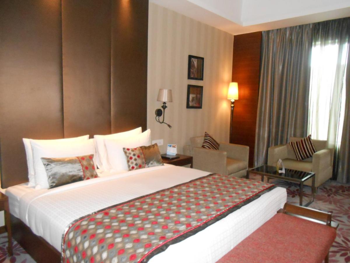 a hotel room with a large bed in a room at Pride Plaza Hotel, Kolkata in Kolkata