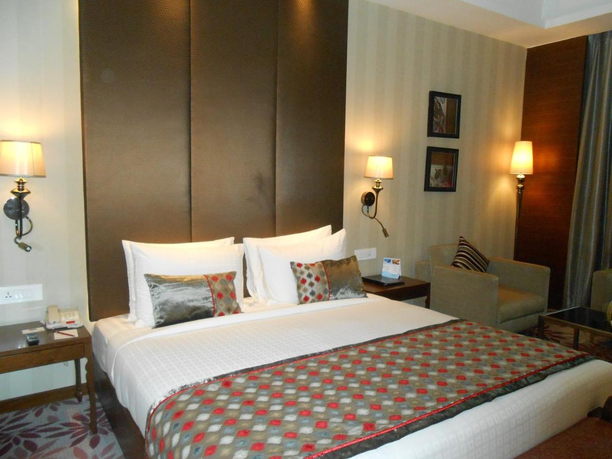 a bedroom with a large bed in a hotel room at Pride Plaza Hotel, Kolkata in Kolkata