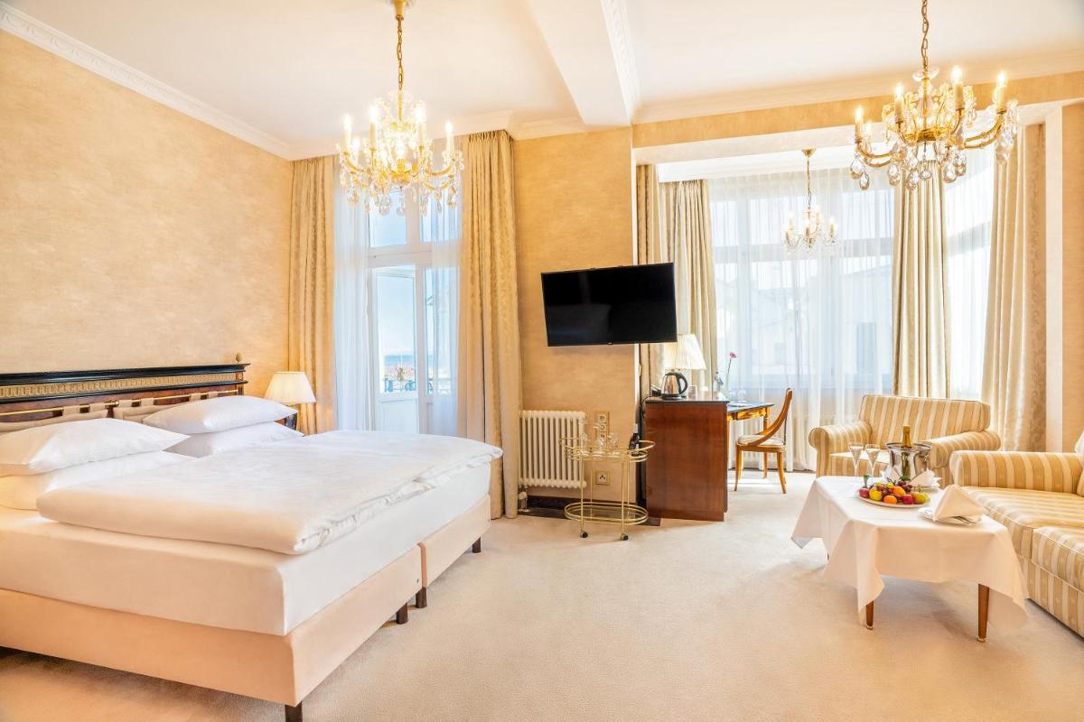 ein Hotelzimmer mit einem Bett und einem Esszimmer in der Unterkunft SEETELHOTEL Ahlbecker Hof das elegante Traditionshotel & ruhiger Rückzugsort an der Ostsee in Ahlbeck