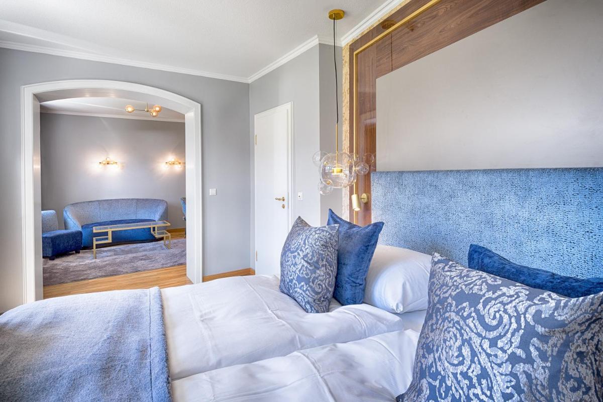 Ein Bett oder Betten in einem Zimmer der Unterkunft Parkhotel Adler
