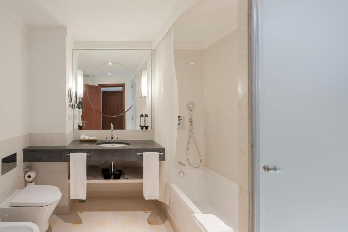 um banheiro com uma pia, um vaso sanitário e uma banheira em Terra Nostra Garden Hotel nas Furnas