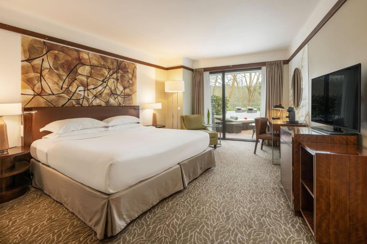 um quarto com uma cama grande e uma TV de tela plana em Terra Nostra Garden Hotel nas Furnas