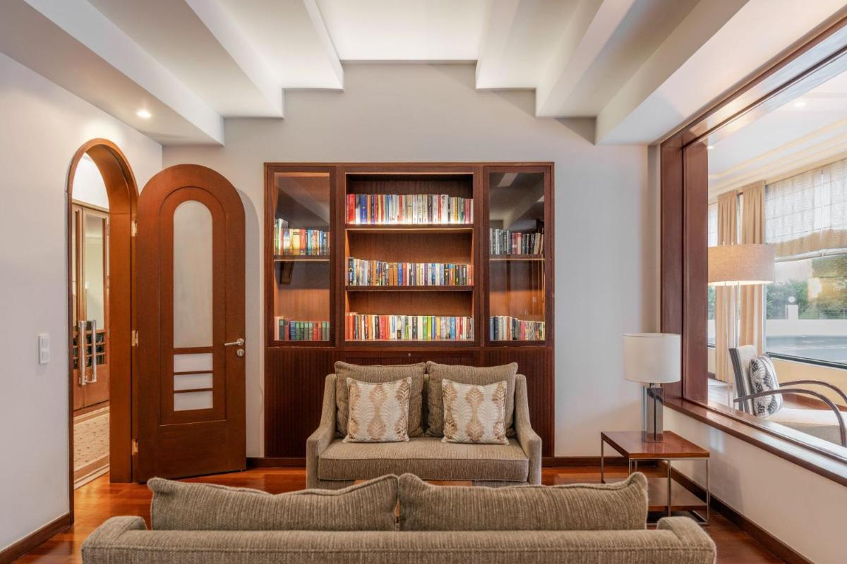 uma sala de estar com um sofá e uma estante de livros em Terra Nostra Garden Hotel nas Furnas