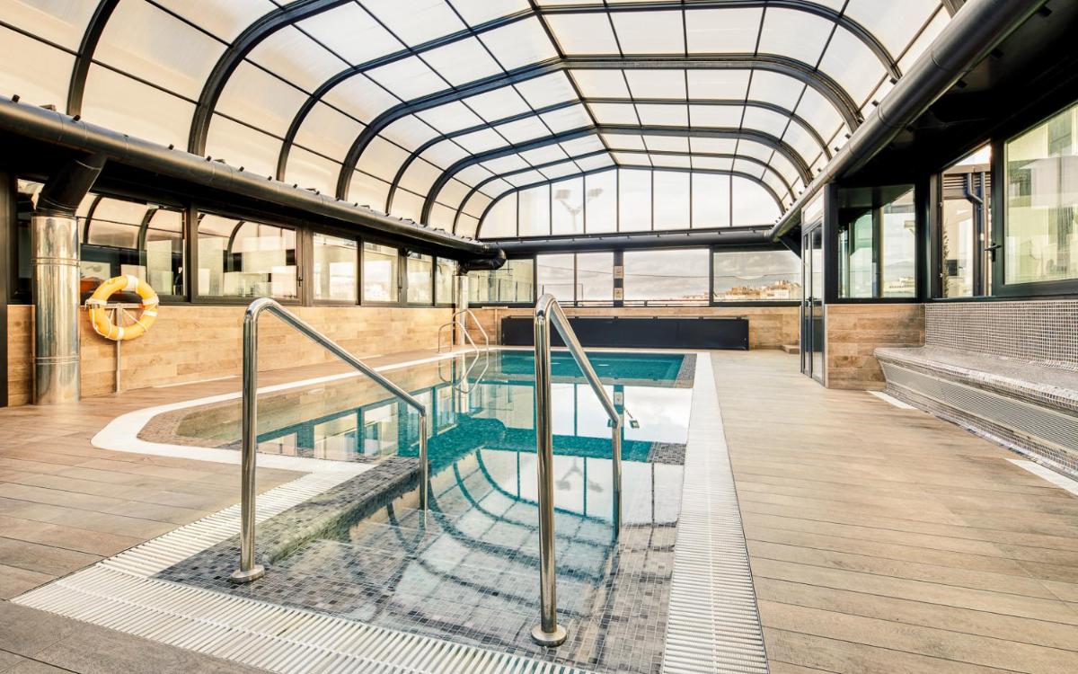 una piscina en un edificio con techo de cristal en Gran Hotel Luna de Granada, en Granada