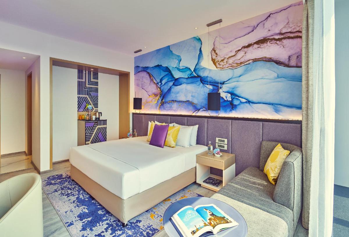 a hotel room with a bed and a couch at Vivanta Navi Mumbai Turbhe in Navi Mumbai