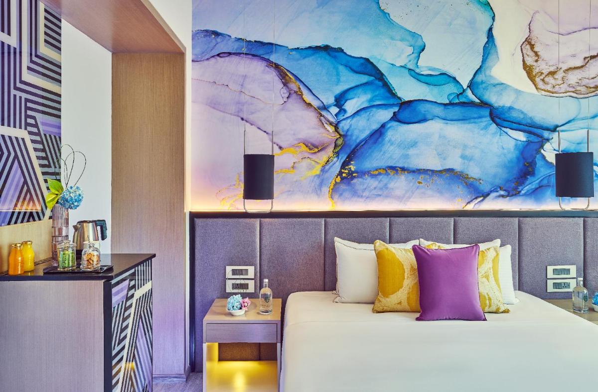 a bedroom with a bed and a painting on the wall at Vivanta Navi Mumbai Turbhe in Navi Mumbai