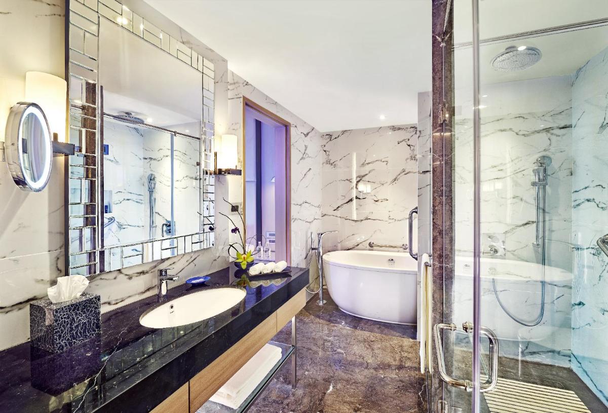 a bathroom with a tub and a sink at Vivanta Navi Mumbai Turbhe in Navi Mumbai