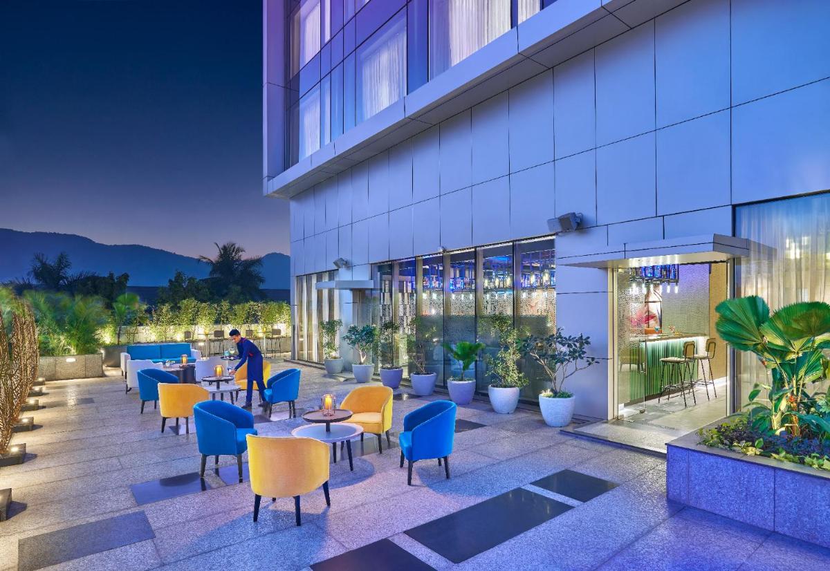 a rendering of a hotel patio with tables and chairs at Vivanta Navi Mumbai Turbhe in Navi Mumbai