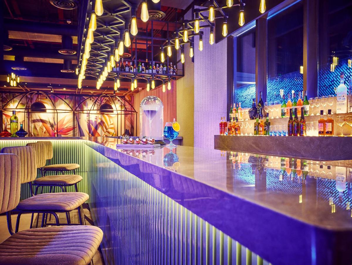 a bar with chairs and a purple counter in a room at Vivanta Navi Mumbai Turbhe in Navi Mumbai