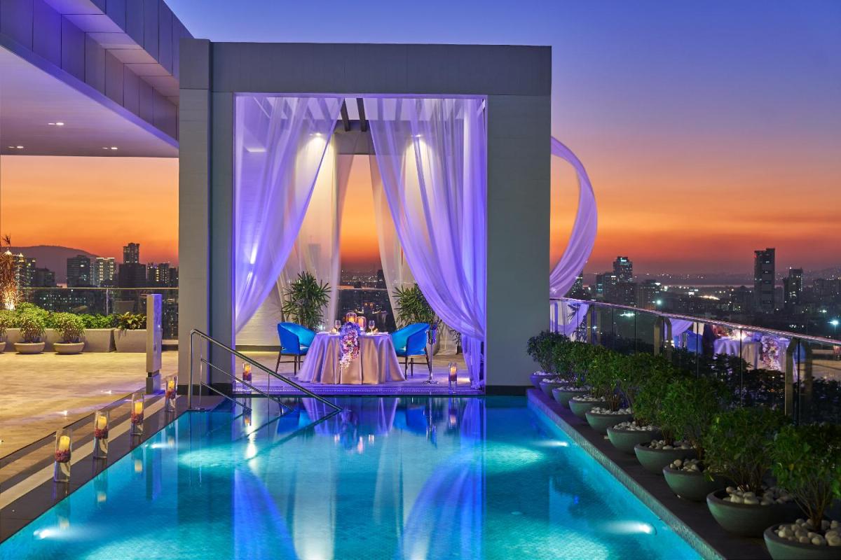 a dinner table on the balcony of a building at Vivanta Navi Mumbai Turbhe in Navi Mumbai