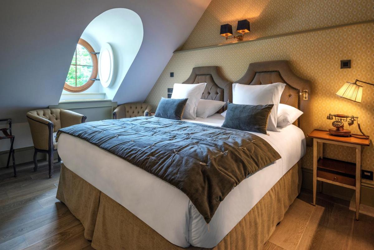 une chambre avec un grand lit et une fenêtre dans l'établissement Château Brachet, à Grésy-sur-Aix