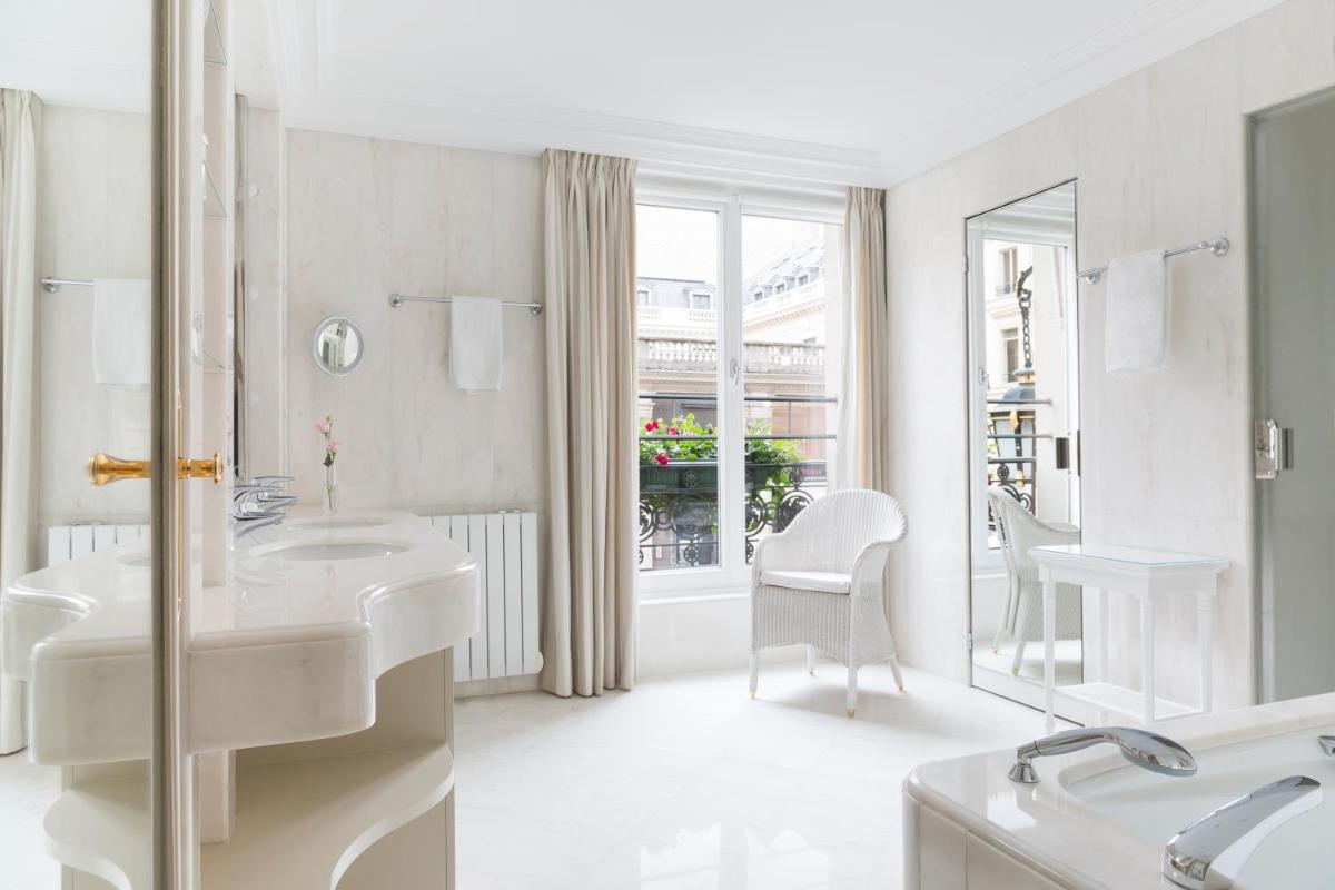 une salle de bain blanche avec deux lavabos et un miroir dans l'établissement Le Bristol Paris, Oetker Hotels, à Paris