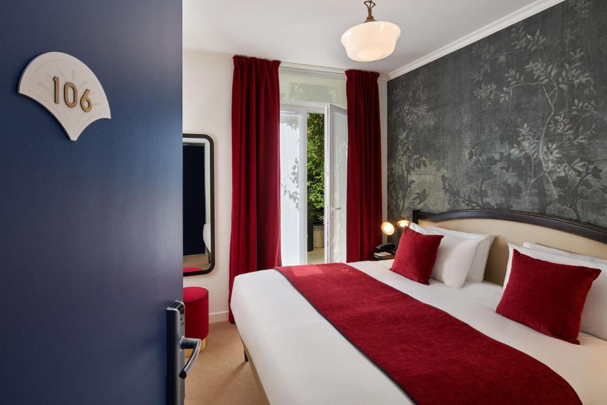 - une chambre avec un grand lit et des rideaux rouges dans l'établissement Hotel Villa Romantic & Spa, à Paris