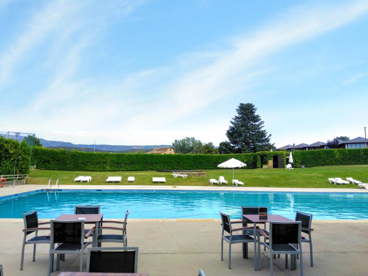 una piscina con mesas y sillas frente a ella en Montanyà, en Seva