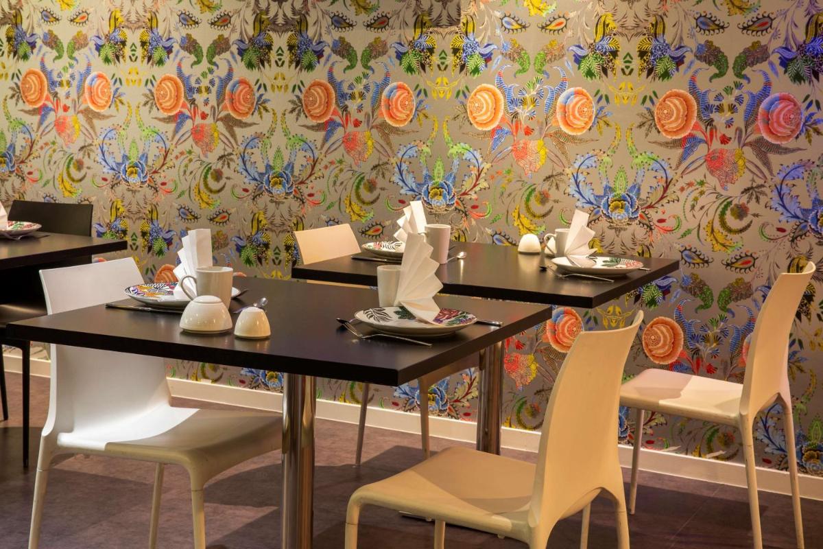 - une salle à manger avec des tables, des chaises et du papier peint dans l'établissement Best Western Plus Thionville Centre, à Thionville