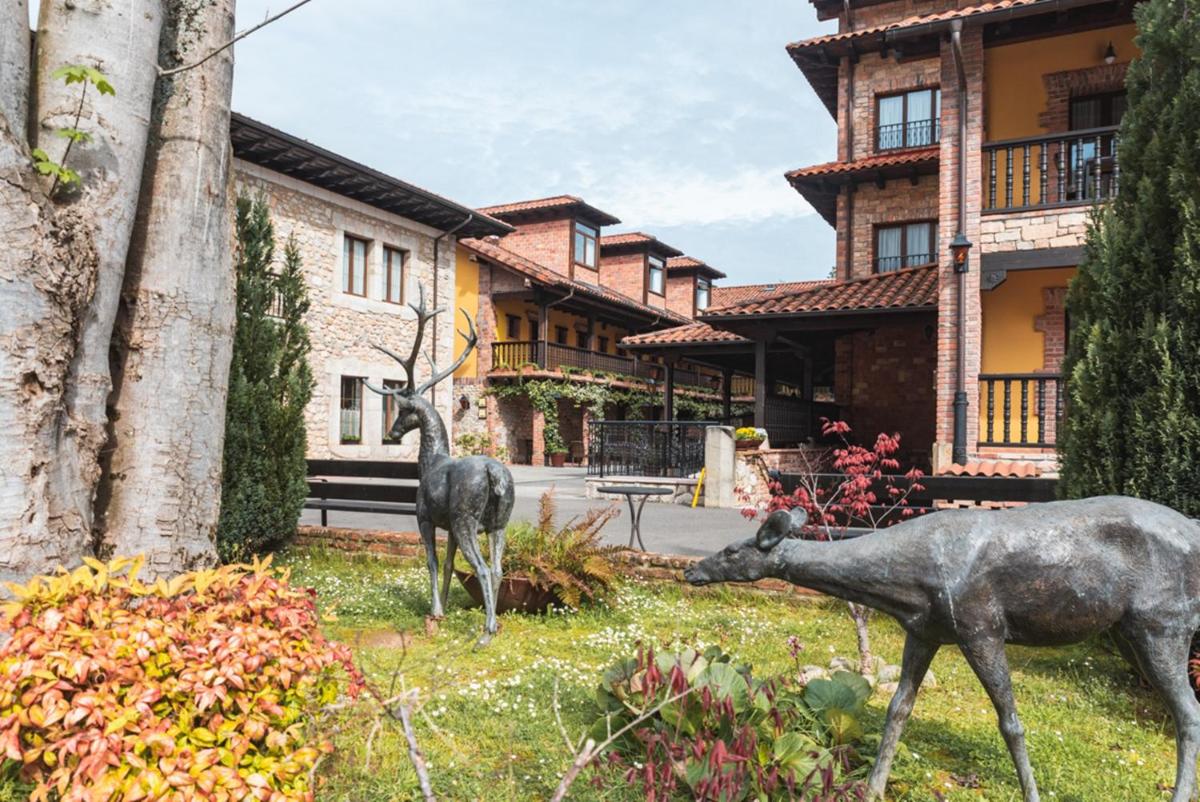 Dos estatuas de ciervos frente a una casa en Hotel & Spa María Manuela, en Onís