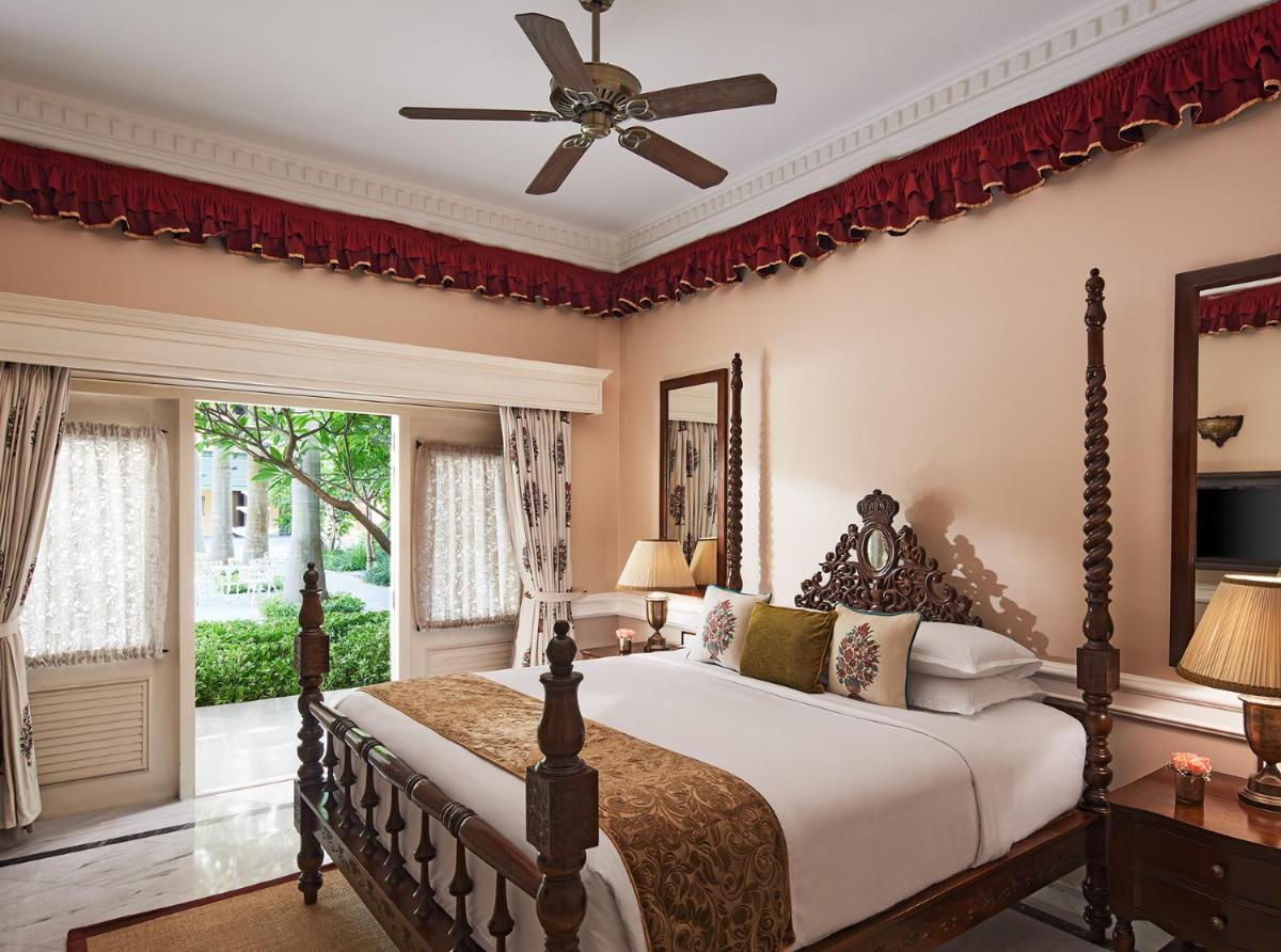 a bedroom with a large bed with a ceiling fan at Raajkutir - IHCL SeleQtions in Kolkata a bedroom with a large bed with a ceiling fan at Raajkutir - IHCL SeleQtions in Kolkata