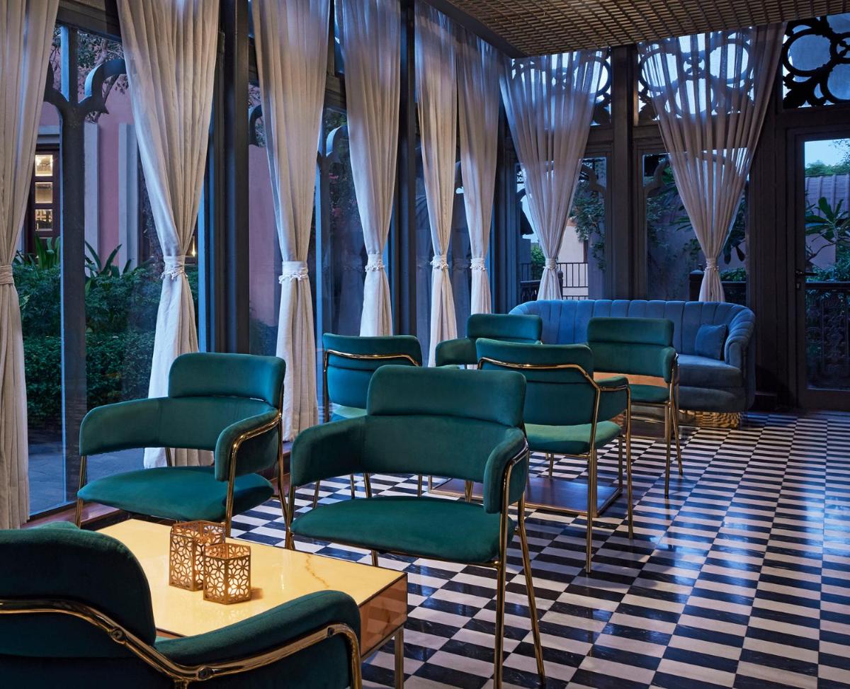 a waiting room with chairs and tables and curtains at Raajkutir - IHCL SeleQtions in Kolkata